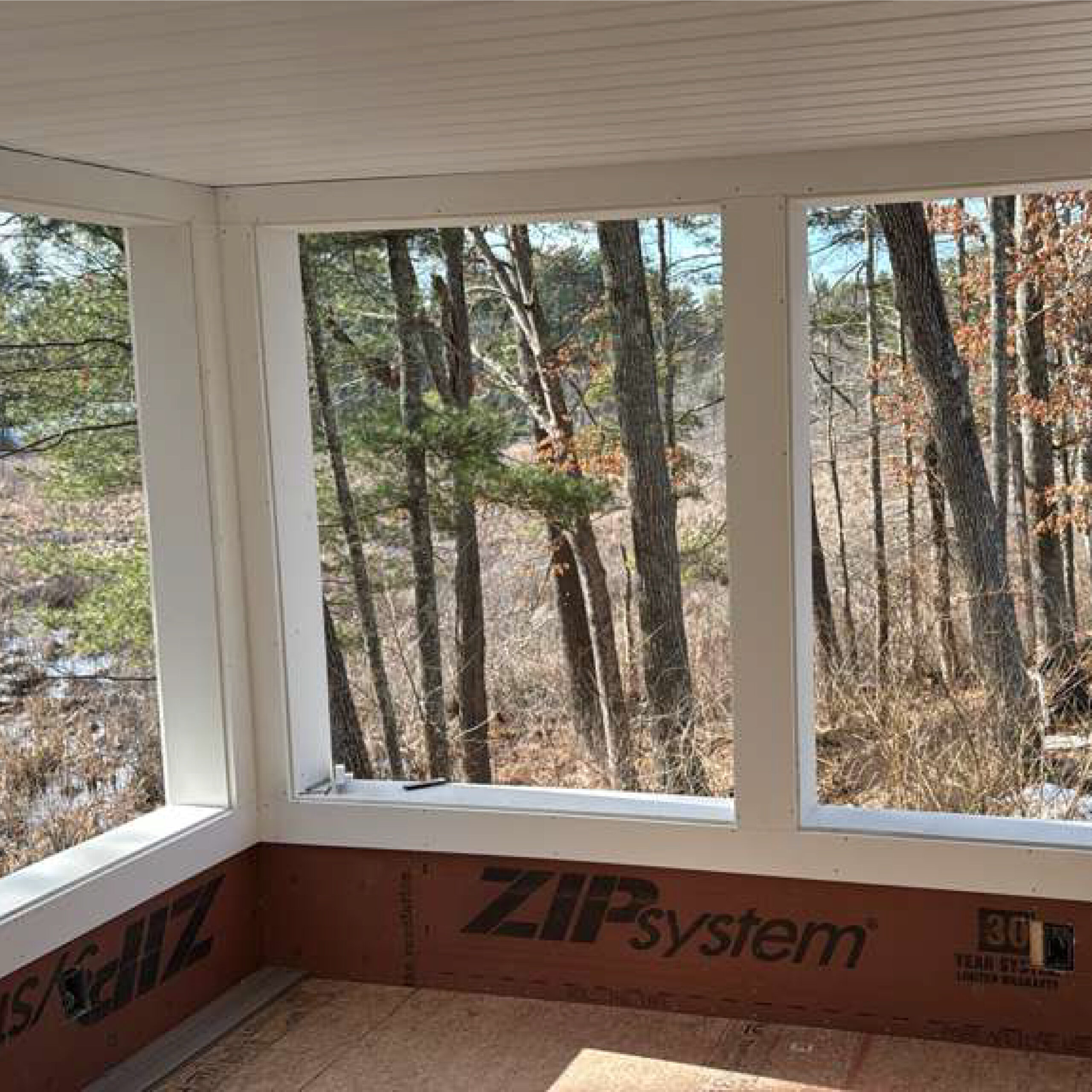Interior sunroom with forest views designed by Family Realty Holdings