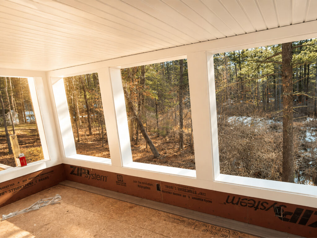 Modern sunroom interior project by Family Realty Holdings with wooded landscape views