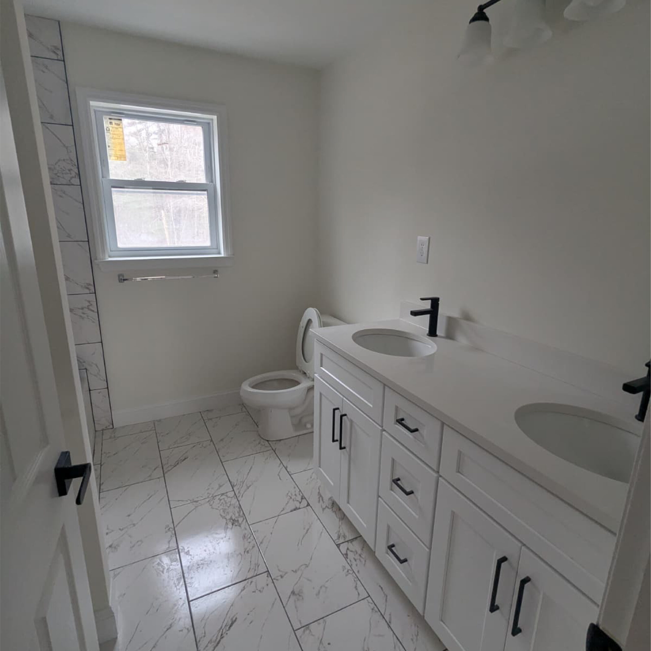 Modern bathroom vanity and marble flooring by Family Realty Holdings