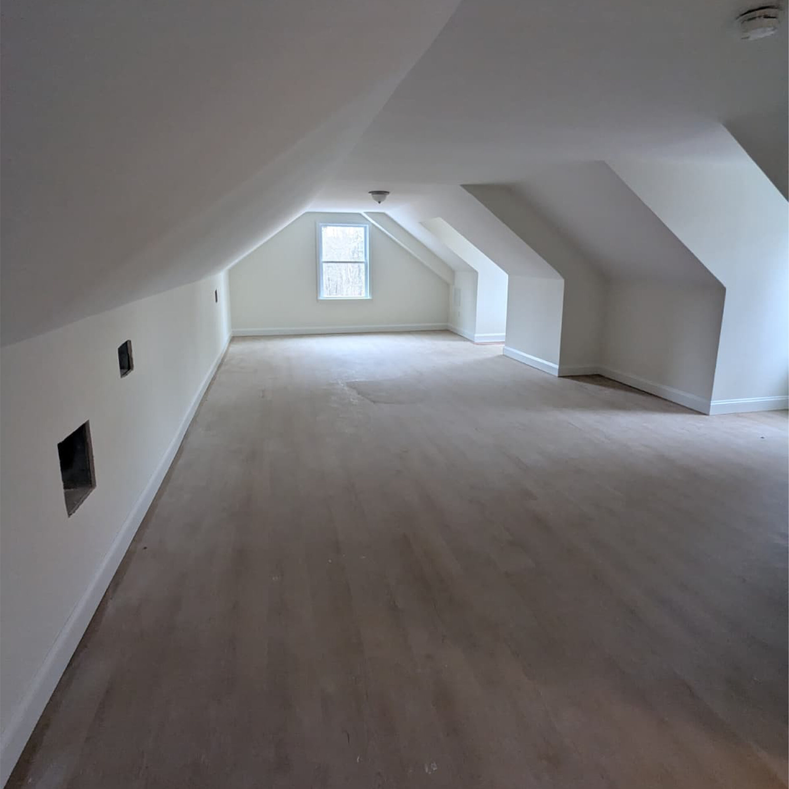 Finished attic living space by Family Realty Holdings with vaulted ceiling